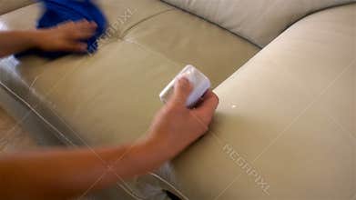 Cleaning sofa with sponge and cloth