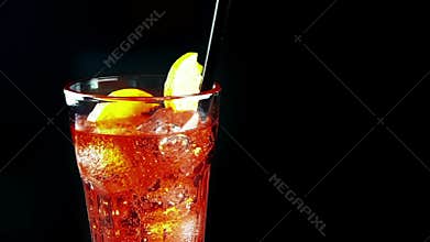 Barman prepare the drinking glass of spritz aperitif aperol orange cocktail with ice cubes and orange slice, with fizzy bubbles