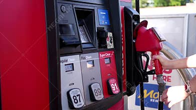 Motion of people filling up car gas tank with fuel