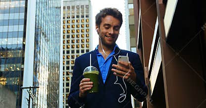 Businessman talking on mobile phone while having juice