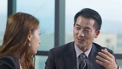 Asian businessman and businesswoman discussing business in office