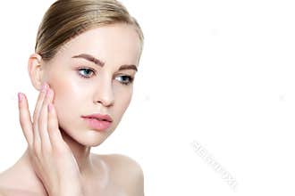 Beautiful Young Blond Woman with Perfect Skin touching her face. Facial treatment. Cosmetology, beauty and spa concept