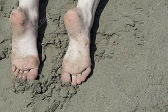 Holiday concept. Woman feet close-up relaxing on beach, enjoying sun and splendid view