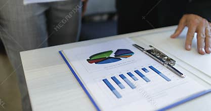 Businessman and businesswoman analyzing financial data hold reports documents business people discuss market matters