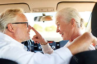 Happy senior couple driving in car