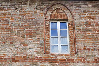 Castle window in a medieval style. Double arched window on a facade of medieval wall. Biforium - ancient window with
