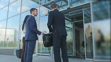 The airport employee greets the couple entering the airport building