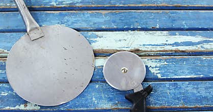 Pizza peel and cutter on wooden table
