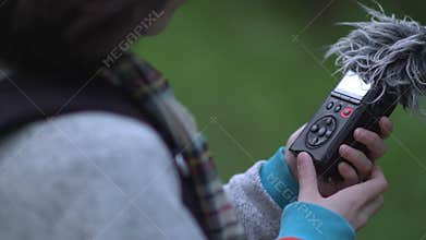 Woman with audio recorder in forest