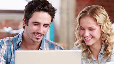 Casual business team using laptop at desk