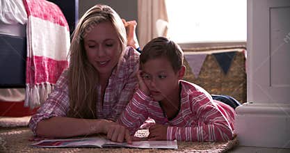 Mother And Son Reading Book In Child's Bedroom