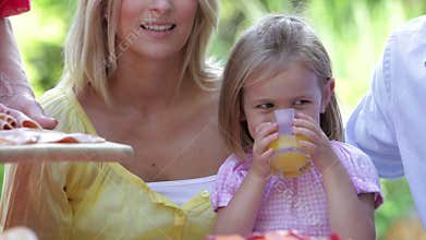 Young Girl At Family Meal Drinking Orange Juice