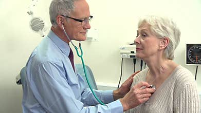 Doctor Listening To Senior Female Patient's Chest