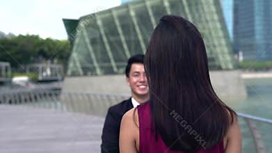 Asian man running to greet his girlfriend embracing