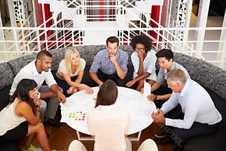 Group of work colleagues having meeting in an office lobby