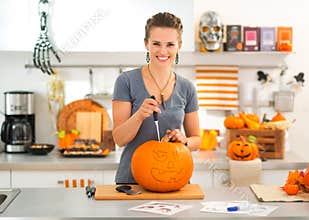 Woman carving a pumpkin Jack-O-Lantern for Halloween party