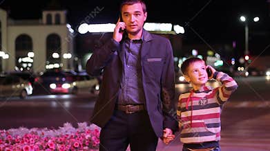 Man and child go through the city night and