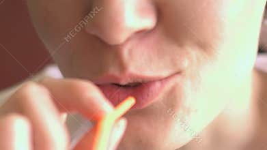 Girl drinks cocktail through a straw.