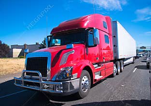 Red fency big rig semi truck modern trailer interstate highway