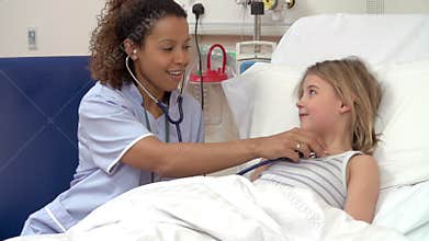 Nurse With Stethoscope Examining Young Girl In Hospital Bed