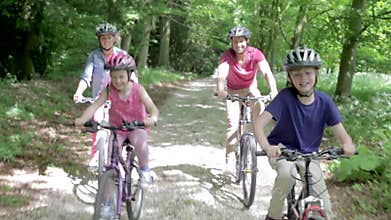 Family Riding Mountain Bikes Along Track