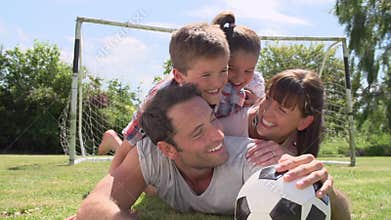 Family Playing Football In Garden Together