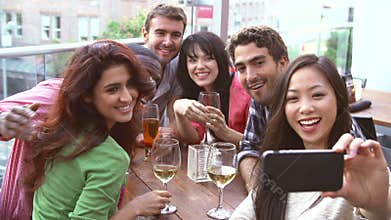 Group Of Friends Taking Photograph At Outdoor Rooftop Bar