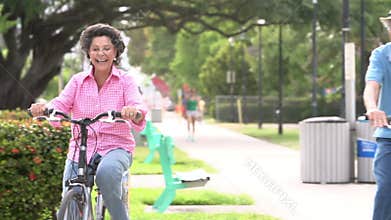 Slow Motion Sequence Of Senior Couple Riding Bikes In Park