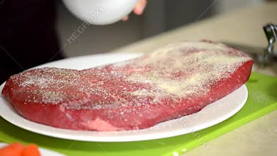 Woman preparing a beef steak.