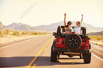 Friends On Road Trip Driving In Convertible Car
