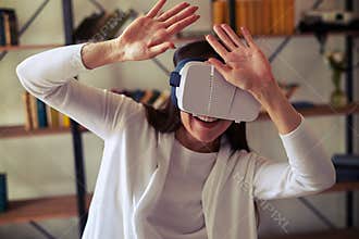 Woman hiding from something using hi-tech virtual reality headset