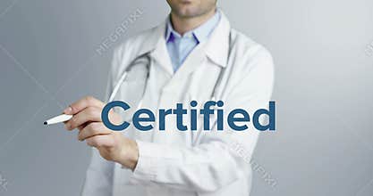 A charming young doctor writes and underlines the importance of the word Certified on a neutral background with a blue marker
