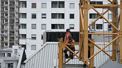 Builders assemble a construction tower crane
