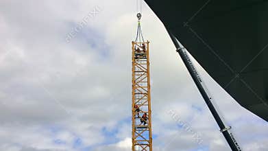 Time lapse of builders assemble a tower crane