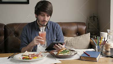 Hipster Man Using Digital Tablet Eating Healthy Breakfast