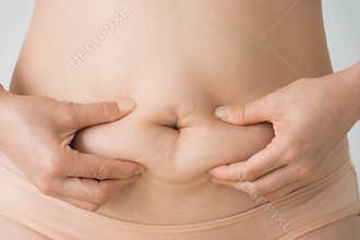Woman squeezes belly fat