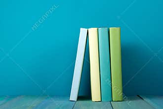 Row of colorful books, grungy blue background, free copy space