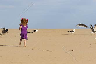 Little girl with red hair chasing birds