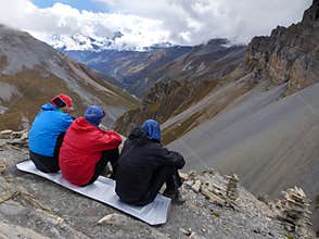 Looking down to the valley, Hikers Resting on a Ridge Overlooking Annapurna Mountain Range, Nepal