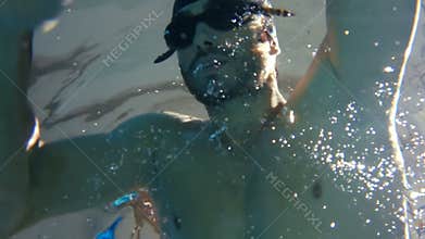 Underwater view of man swimming and diving
