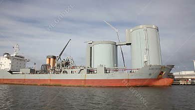 Sailing pass a cement carrier at a factory