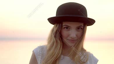 Close up portrait of pretty woman smiling at sunset sea background