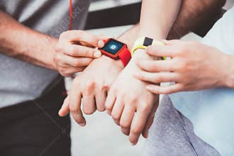 Athletic people sharing workout data from their smartwatches.