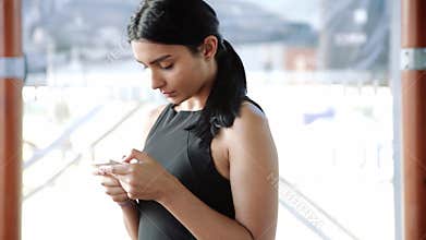 Smartphone girl using app on phone in cafe. Beautiful multicultural young casual female professional on mobile phone.
