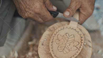 Woodcarver work in his workshop. Making wooden spoon with the knife