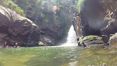 ELLA, SRI LANKA - MARCH 2014: Man jumping into the river next to beautiful waterfall