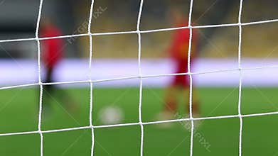 View of goal net with soccer pitch background