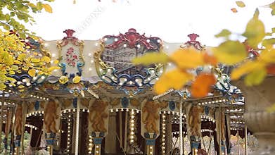 Yellow autumn leaves with merry-go-round in background