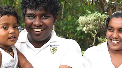KANDY, SRI LANKA - FEBRUARY 2014: Tracking shot of young couple with a baby in the botanical gardens in Kandy. The gardens attract