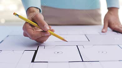 Woman with architectural blueprint and pencil